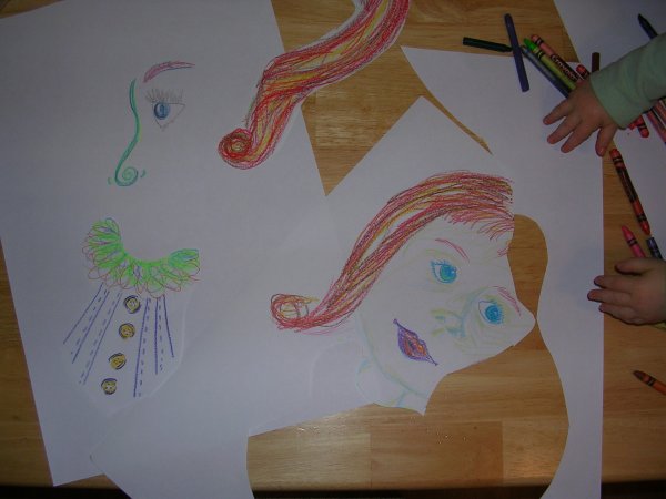 Cut-up crayon face drawings being rearranged into Cubist pieces